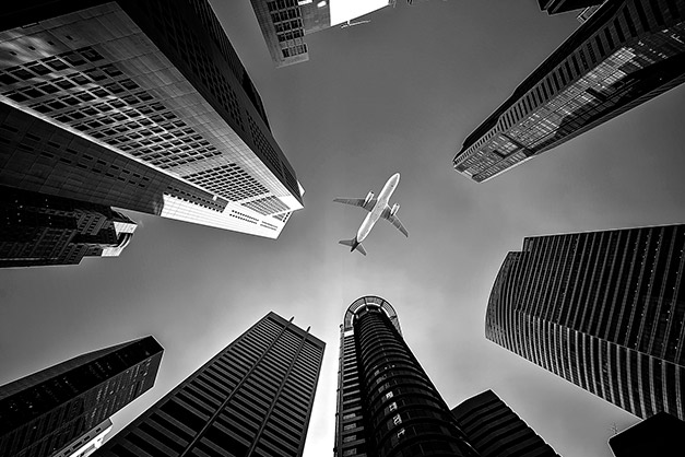 low angle view of buildings with airplane composition tip leading lines