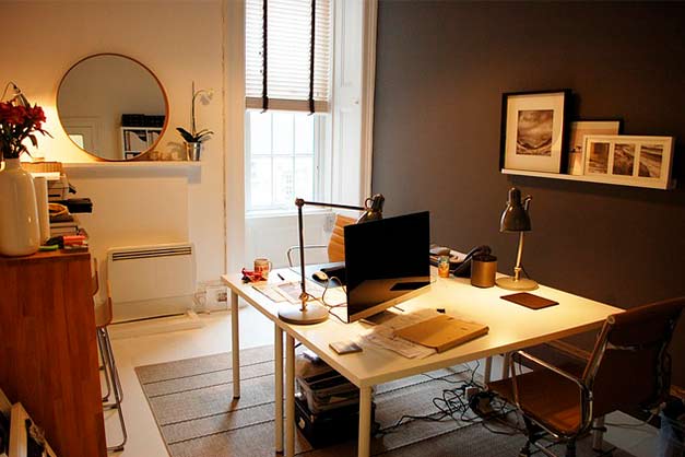framed prints leaning on shelf inside small office space
