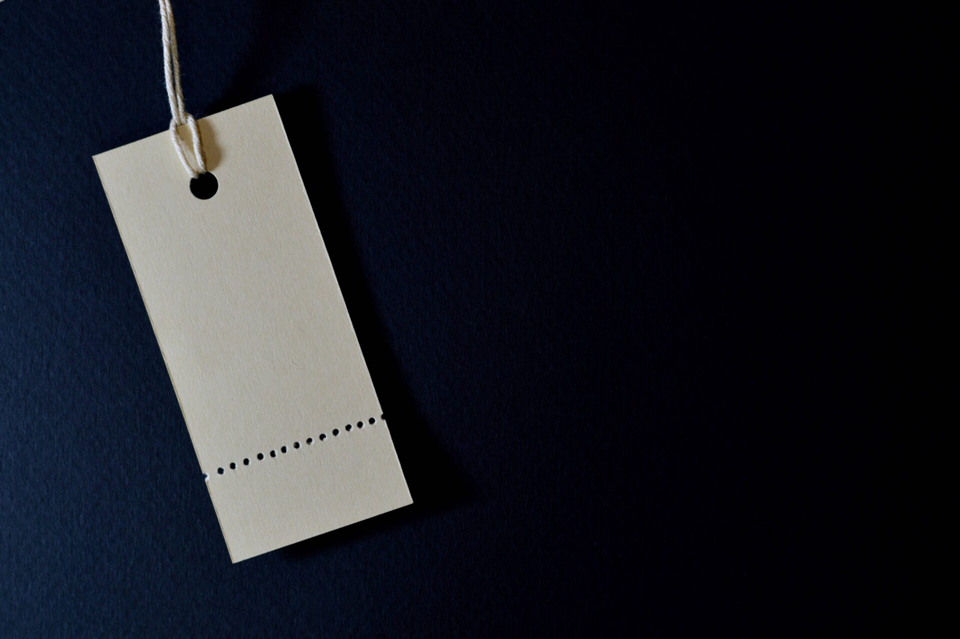 Blank product hang tag on a dark background representing branding for a dropshipping store