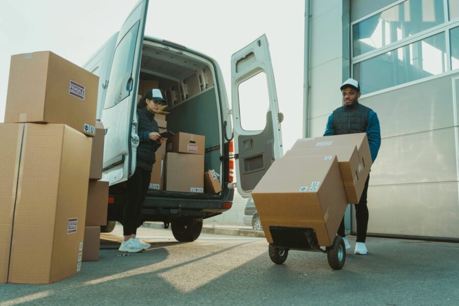Fulfillment workers loading packed boxes into a delivery van for print on demand orders