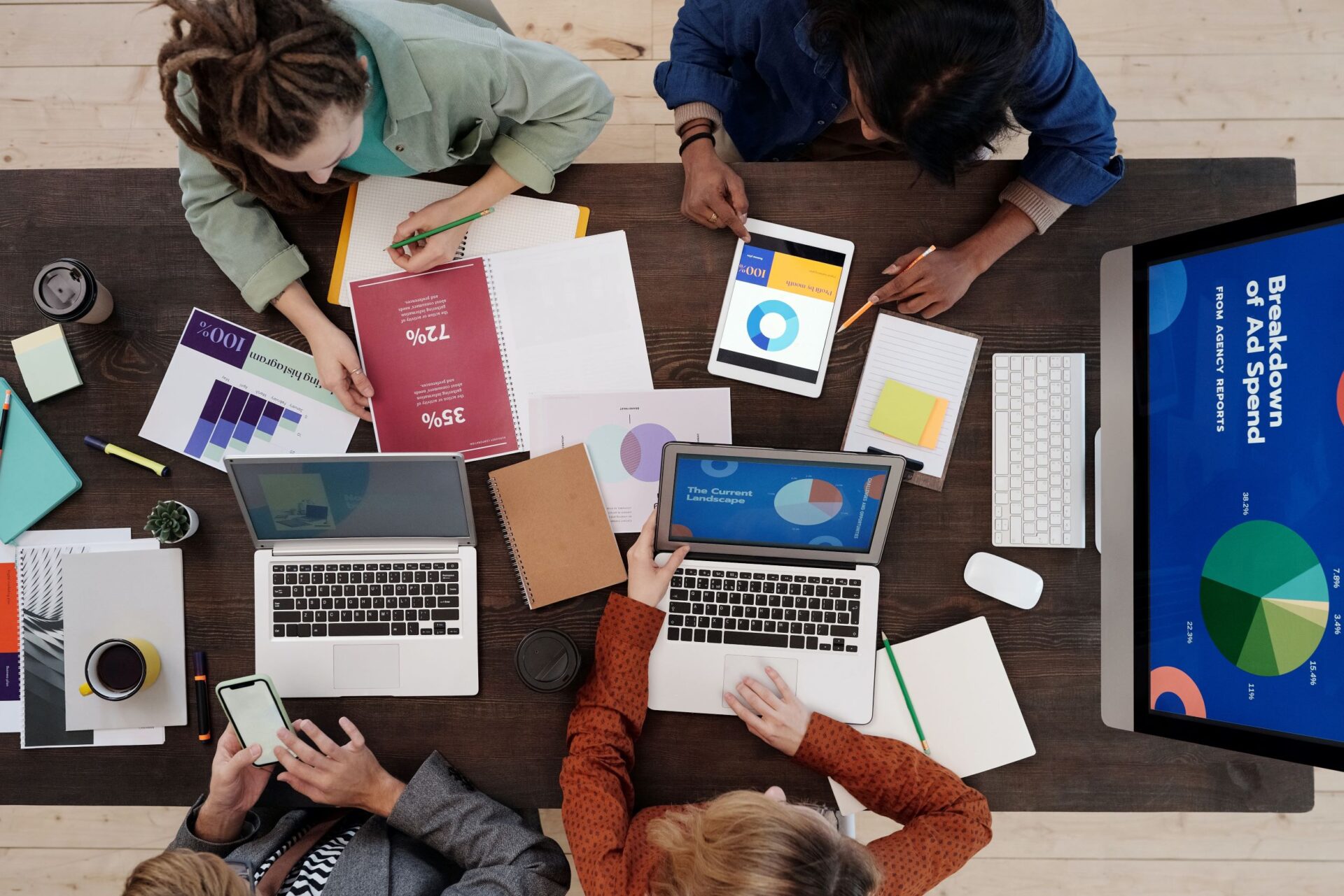 Marketing team reviewing reports and analytics on laptops while planning a content marketing strategy