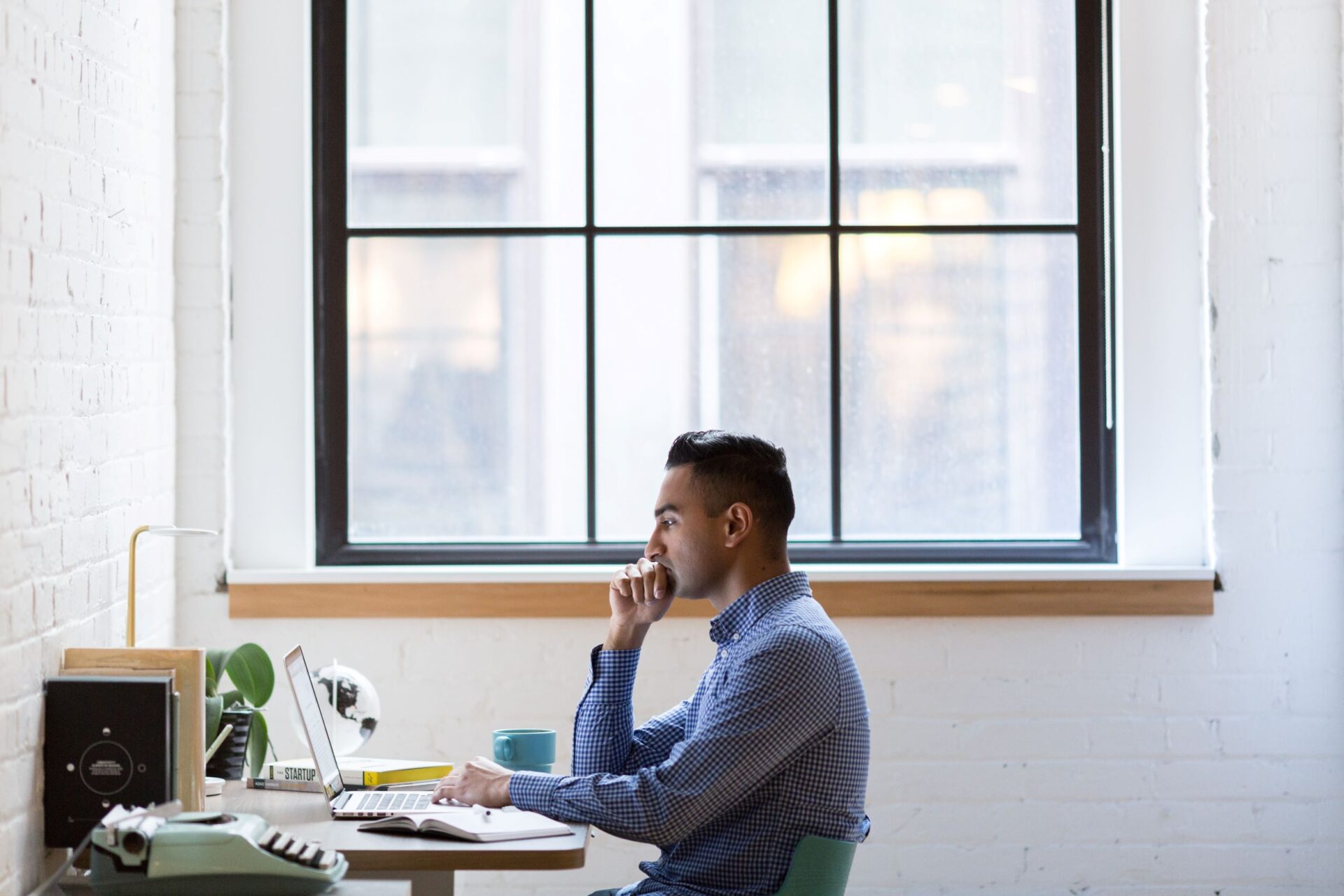 person-in-front-of-work-table-and-laptop