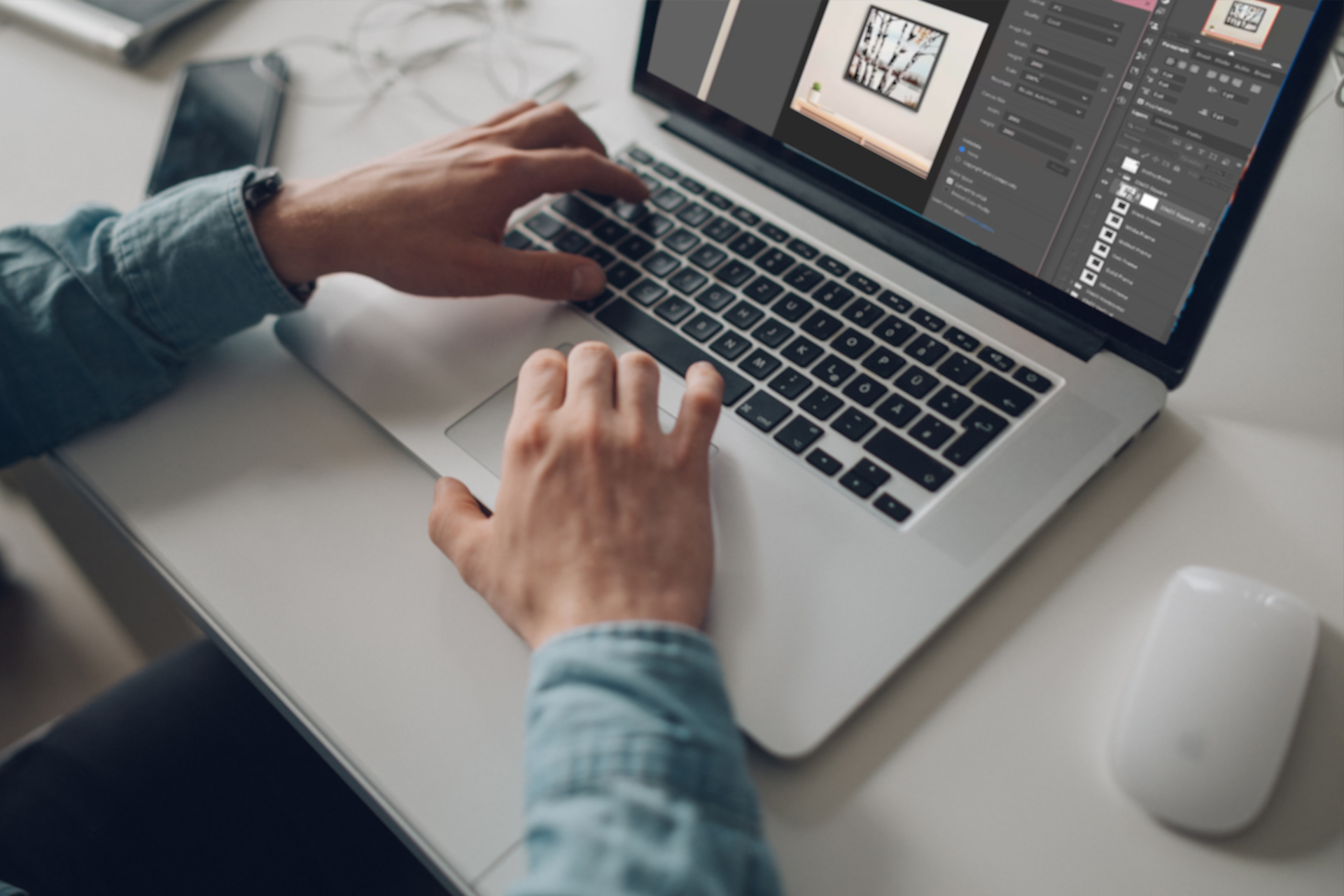 Designer editing a framed wall art mockup template on a laptop to preview artwork on a product