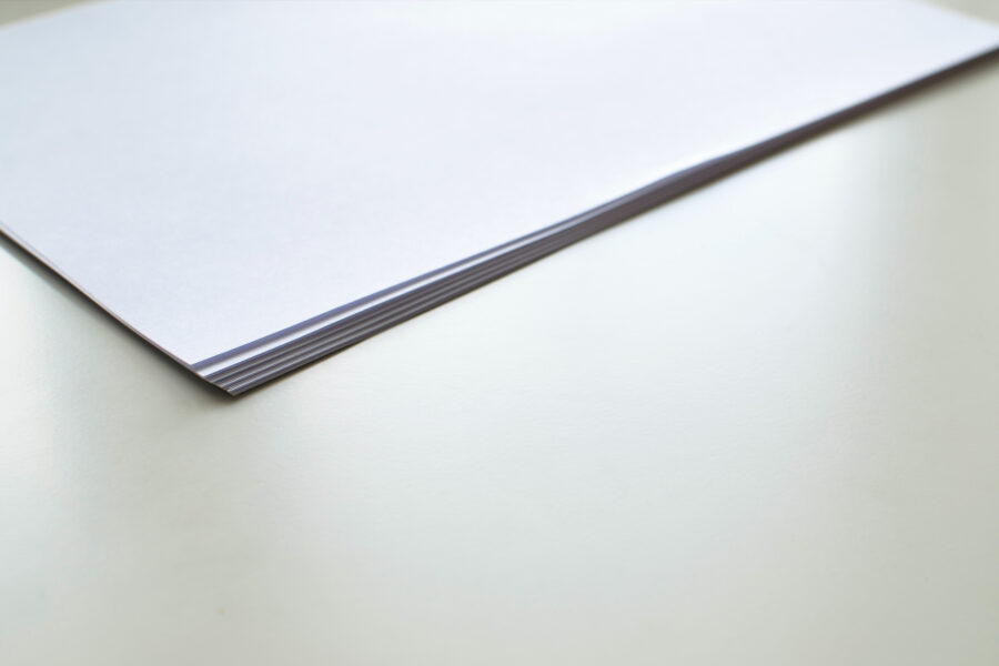 Stack of blank fine art paper sheets showing the smooth matte surface used for art prints