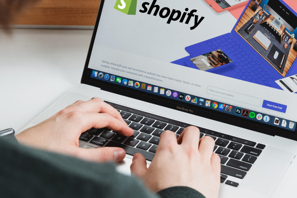Person using a MacBook to access the Shopify website.