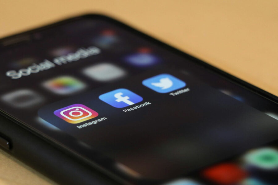 Smartphone showing social media app icons used for running paid ads to promote art prints