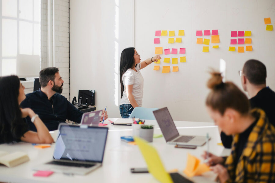 Team meeting with sticky notes on a wall while planning strategic business partnerships