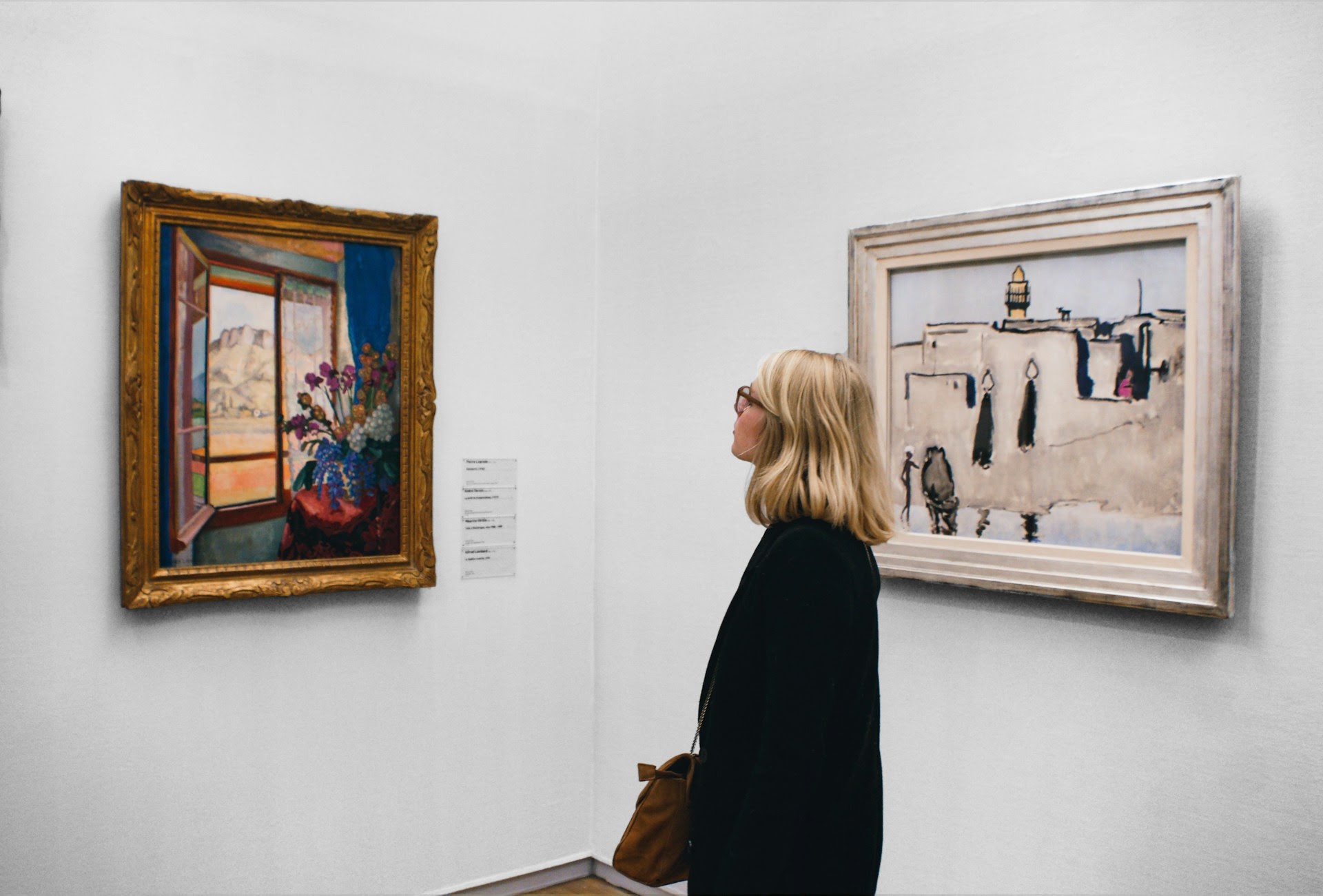 Art gallery visitor viewing framed paintings, representing meaningful customer experiences through art