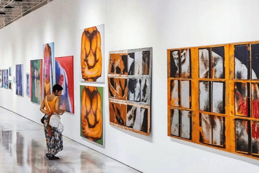 Visitor viewing large contemporary abstract paintings displayed in a modern art gallery