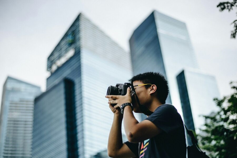 Young photographer taking a photo with a camera in an urban setting