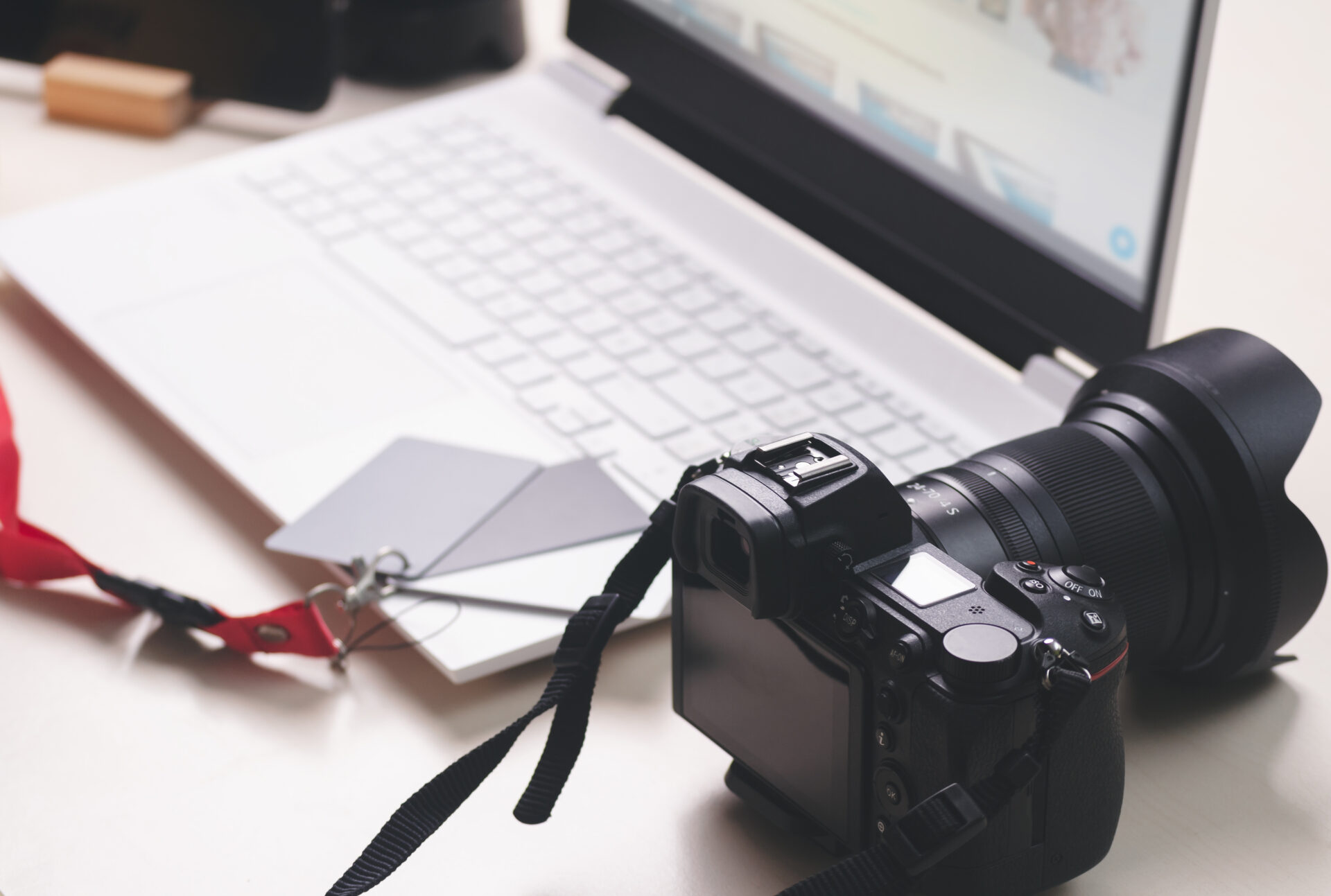 DSLR camera beside a laptop on a photographer's desk used to sell photography prints online