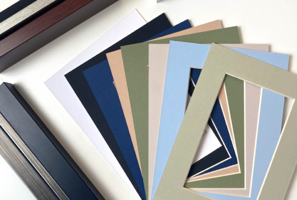 Frame corner samples and colored mat boards laid out for customizing the presentation of wall art