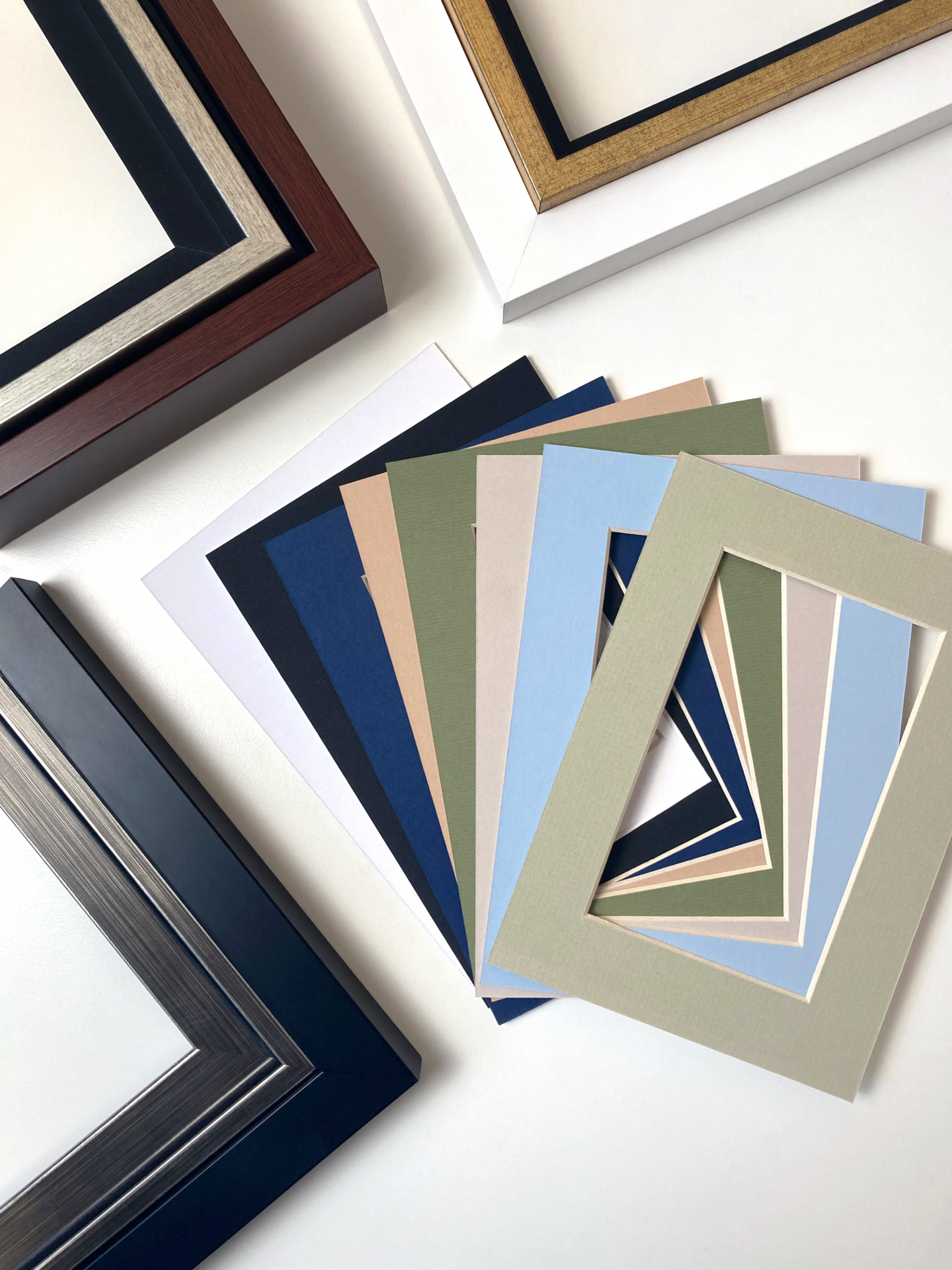 Frame corner samples and colored mat boards laid out for customizing the presentation of wall art